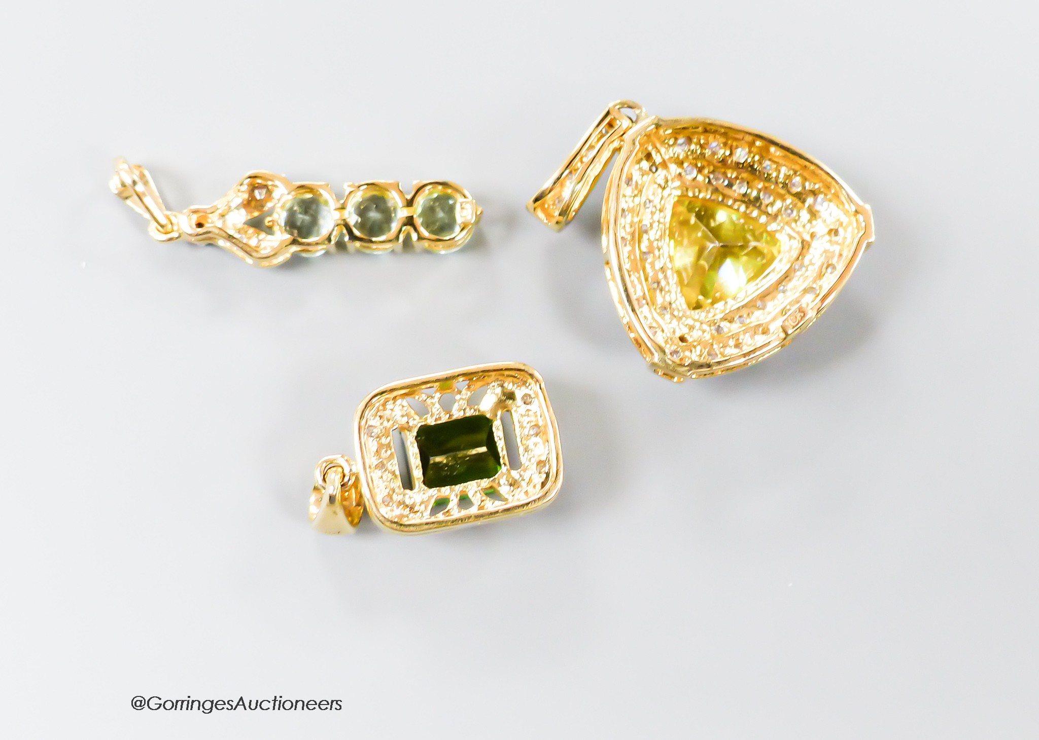 Three assorted modern 18ct gold and gem set pendants, including sphalerite and diamond, overall 27mm, green tourmaline and diamond and three stone tourmaline and diamond chip line pendant, gross 10.5 grams.